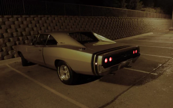A Dodge Charger parked in a dimly lit area, showcasing its sleek design and distinctive rear lights, captured in high-definition for an impressive desktop wallpaper.