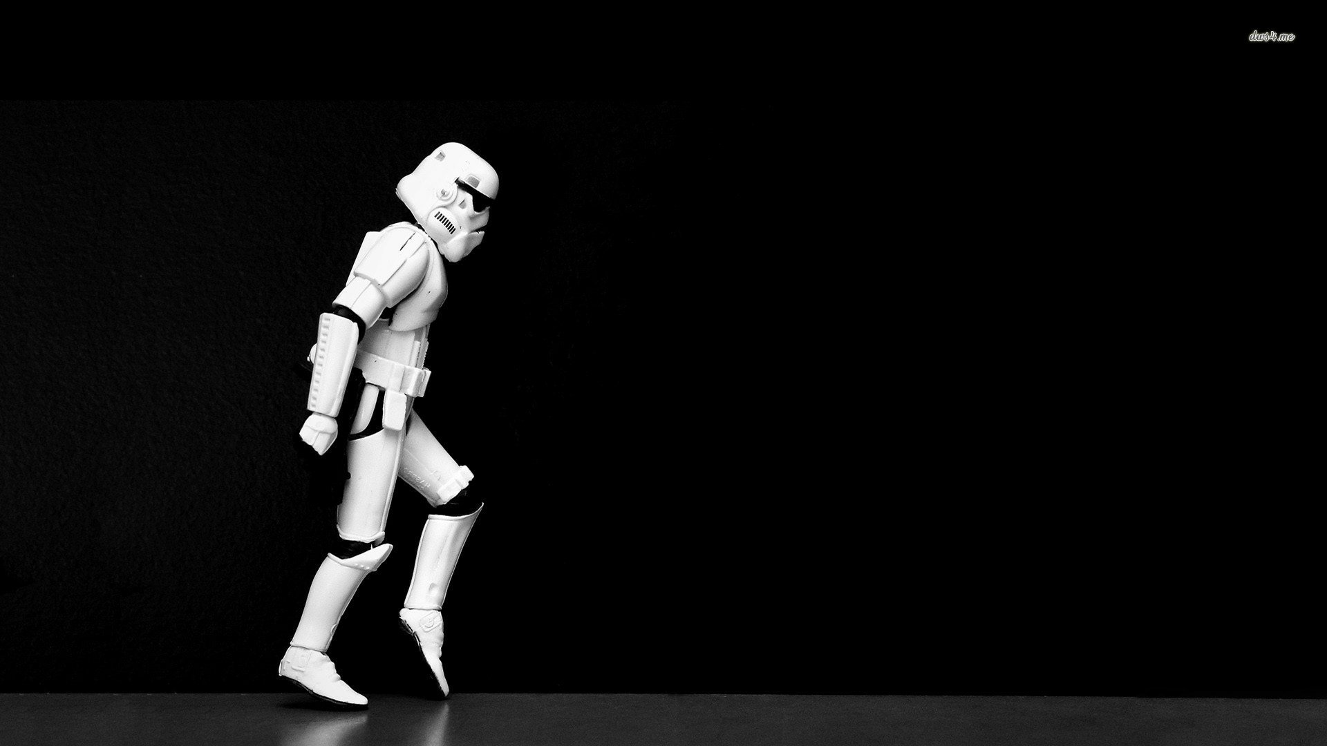 HD PC desktop wallpaper featuring a funny Star Wars stormtrooper in mid-stride against a black background.