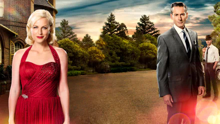 HD PC desktop wallpaper featuring two characters from the TV show A Place to Call Home standing outdoors with trees and a historic building in the background.