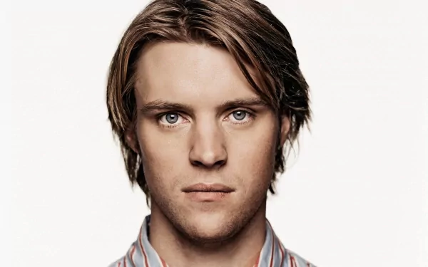 A high-definition desktop wallpaper featuring Jesse Spencer, showcasing his striking features against a simple background.