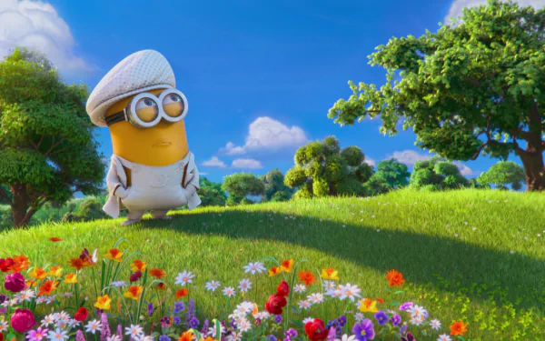 A vibrant HD desktop wallpaper featuring a cheerful Minion from Despicable Me 2, standing in a lush green meadow surrounded by colorful flowers and a bright blue sky.