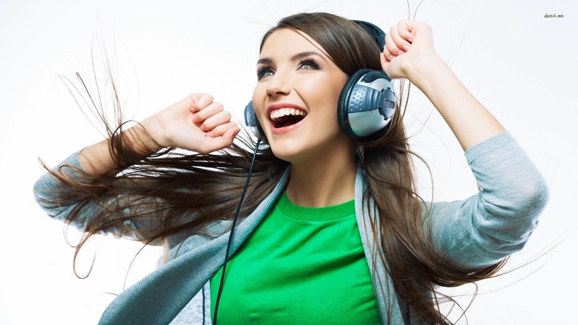 HD PC desktop wallpaper featuring a joyful woman with long hair wearing headphones, radiating a lively and upbeat mood against a white background.