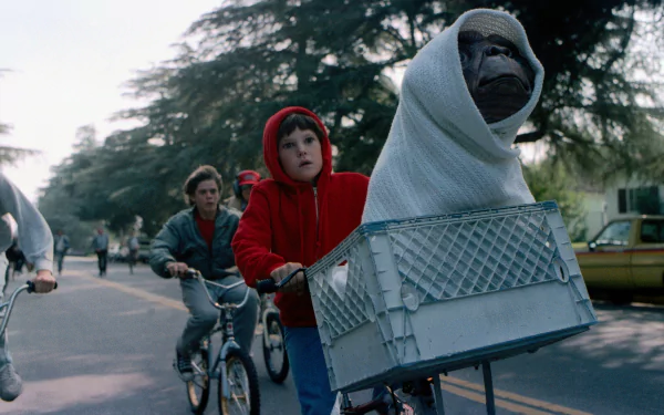 A scene from the movie E.T. the Extra-Terrestrial with a child in a red hoodie biking with E.T. in a basket. HD desktop wallpaper and background.