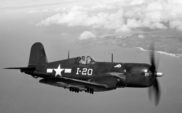 Black-and-white HD desktop wallpaper of a Vought F4U Corsair military aircraft in flight over the coastline.