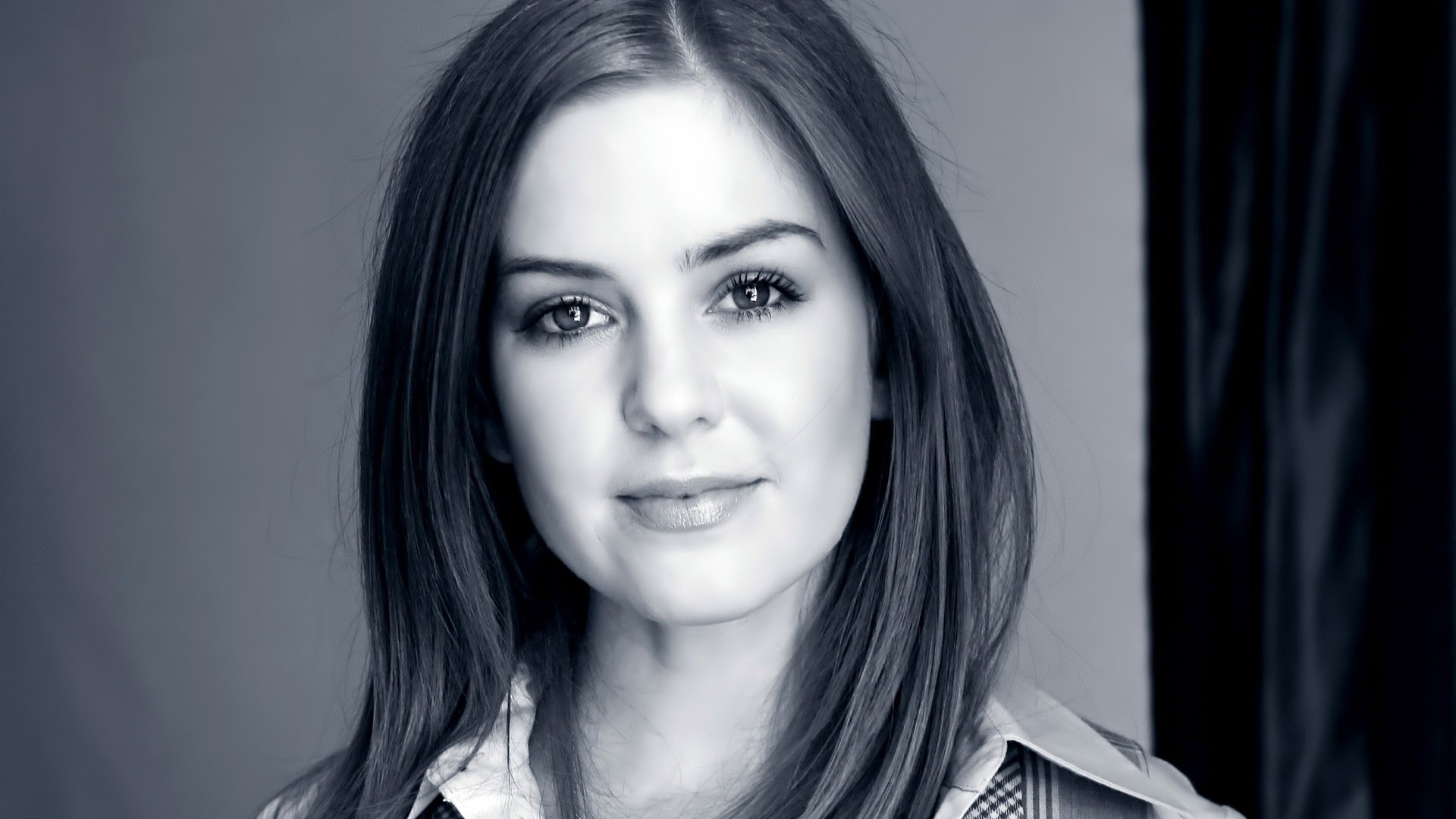 Black and white HD desktop wallpaper featuring Australian actress and celebrity Isla Fisher with a soft smile and straight hair.