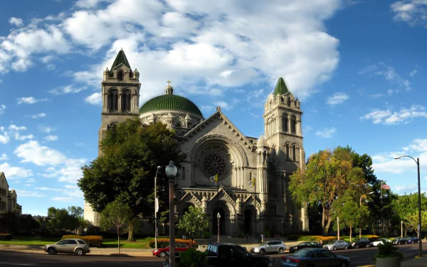 HD desktop wallpaper showcasing the majestic Cathedral Basilica of Saint Louis under a bright, partly cloudy sky, highlighting its religious architecture and twin towers.