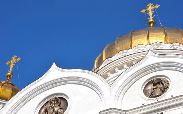 HD PC desktop wallpaper of the religious Cathedral of Christ the Saviour: white facade, golden domes and carved icons set against a vivid blue sky.