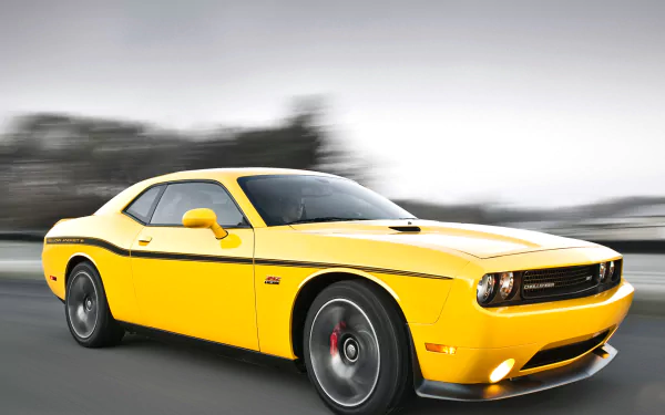 Yellow Dodge Challenger SRT8 392 muscle car speeding on a road, captured in an HD PC desktop wallpaper and background.