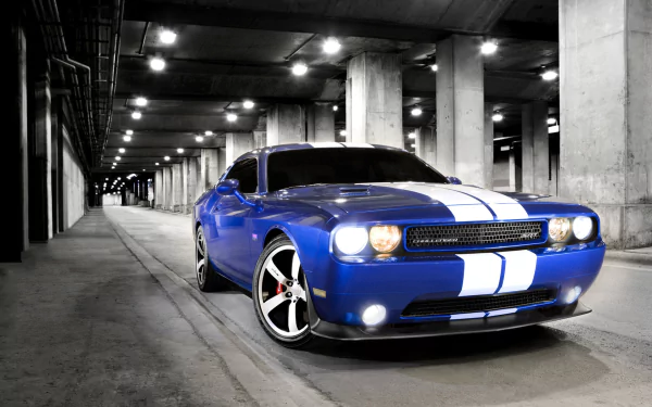 A blue Dodge Challenger SRT8 with white racing stripes parked in a dimly lit underground garage, showcased in a high-definition desktop wallpaper.
