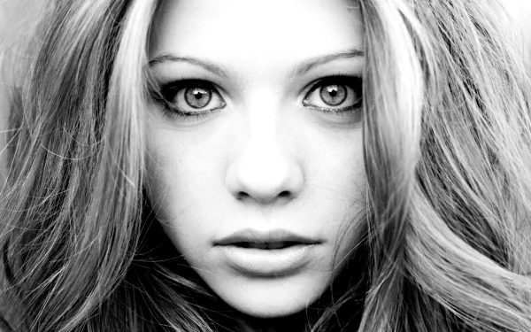 Black-and-white HD desktop wallpaper featuring a close-up portrait of celebrity Michelle Trachtenberg with flowing hair and intense gaze.