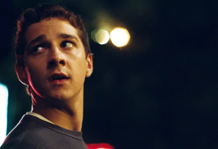 HD wallpaper of a scene from Disturbia featuring a pensive young man in dim lighting.