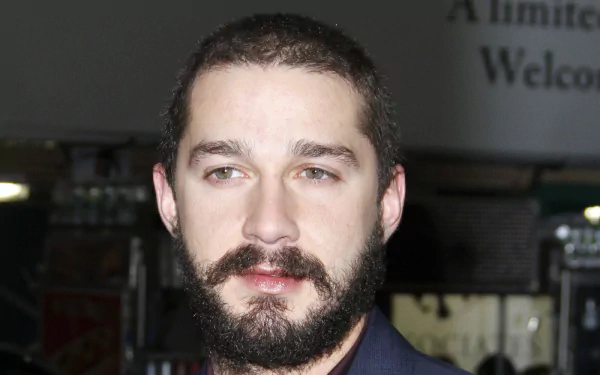 HD desktop wallpaper featuring a portrait of a bearded Shia Labeouf with a focused gaze.
