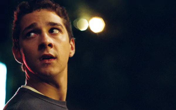 HD wallpaper of a scene from Disturbia featuring a pensive young man in dim lighting.