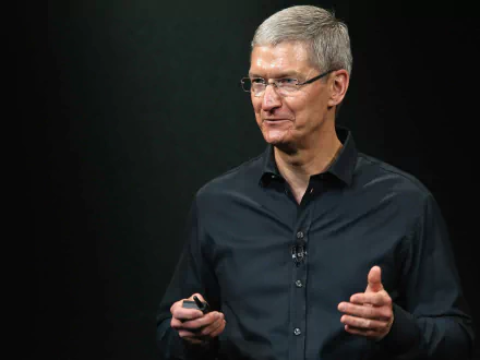 HD desktop wallpaper featuring a man in a dark shirt against a black background, conveying professionalism and leadership.