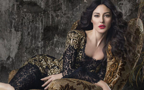 A stunning HD desktop wallpaper featuring Italian actress Monica Bellucci, exuding elegance in a black and gold lace dress against a textured background.