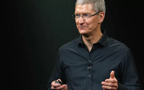 HD desktop wallpaper featuring a man in a dark shirt against a black background, conveying professionalism and leadership.