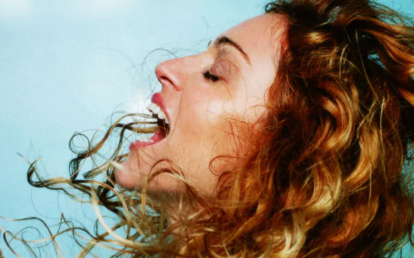 HD desktop wallpaper featuring a close-up of Madonna with flowing hair, captured in a dynamic moment expressing passion for music.