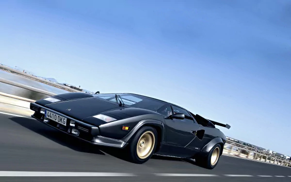 A black Lamborghini Countach speeding on a highway under a clear blue sky, presented as a 4K Ultra HD PC desktop wallpaper background.