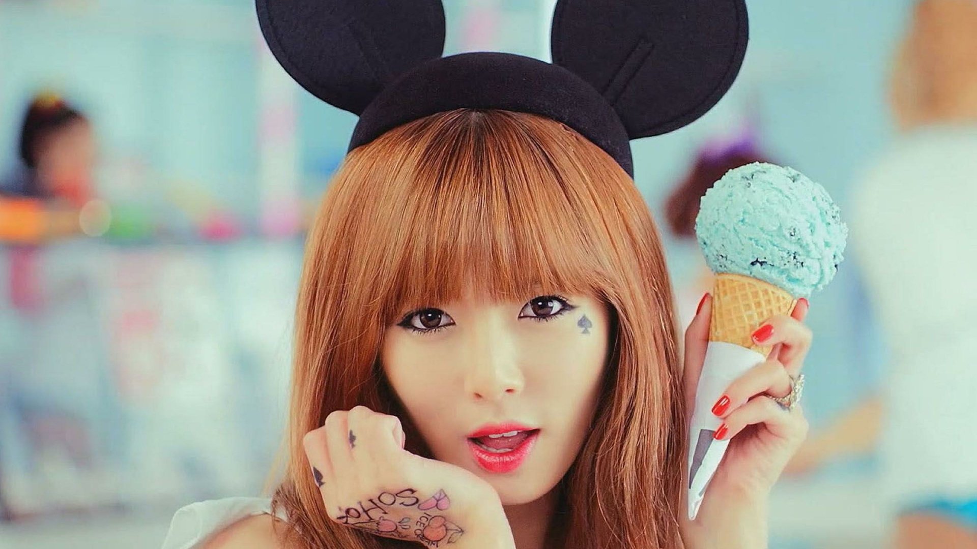 HD PC desktop wallpaper featuring music artist Kim Hyun-a wearing Mickey Mouse ears and holding a mint ice cream cone, with vibrant colors and a playful vibe.
