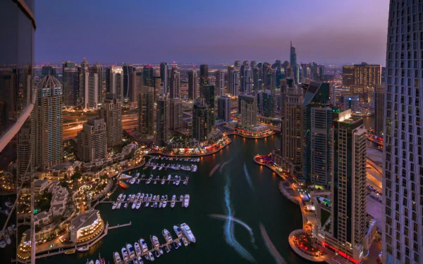 A stunning HD wallpaper showcasing the vibrant skyline of Dubai at dusk, featuring tall skyscrapers, a shimmering marina, and a glowing waterfront.