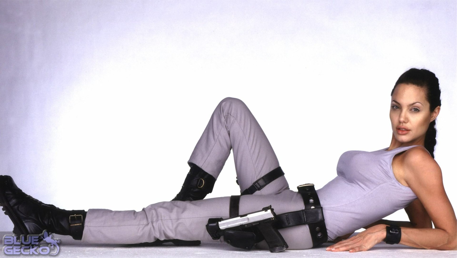 HD PC desktop wallpaper featuring Lara Croft from the movie Lara Croft: Tomb Raider in a relaxed, reclining pose with her signature outfit and weapons.