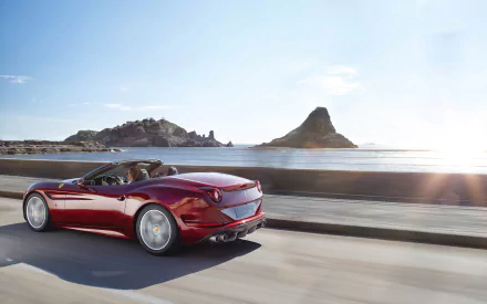 HD desktop wallpaper featuring a sleek red Ferrari California T driving along a coastal road with clear skies and scenic hills in the background.