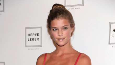 HD desktop wallpaper: portrait of a smiling woman in a red spaghetti-strap dress against a branded event backdrop.