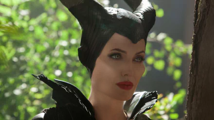 A stunning 4K Ultra HD wallpaper featuring Angelina Jolie as Maleficent, showcasing her iconic dark costume and striking features against a lush, green background.
