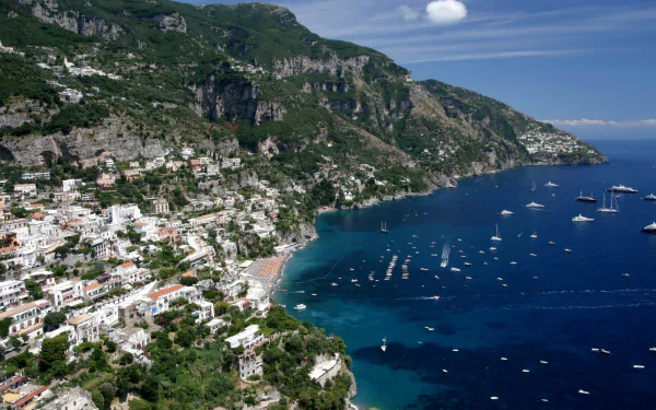 Scenic HD wallpaper of Positano, a picturesque man-made coastal town in Salerno, Italy, featuring colorful buildings cascading down cliffs to the vibrant blue sea.