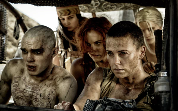 A dynamic scene from *Mad Max: Fury Road*, featuring characters Imperator Furiosa, played by Charlize Theron, and Nux, portrayed by Nicholas Hoult, amidst a tense moment in the post-apocalyptic landscape.