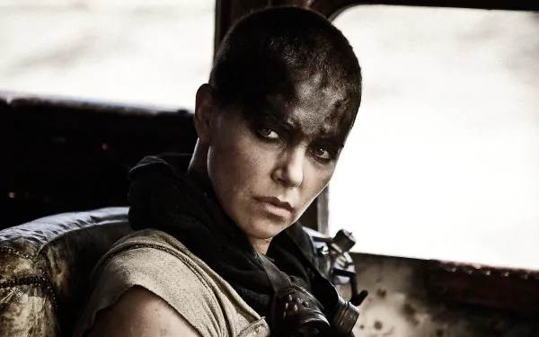 A close-up of Imperator Furiosa, portrayed by Charlize Theron in *Mad Max: Fury Road*, showcasing her fierce expression and dramatic makeup in a gritty, post-apocalyptic setting.