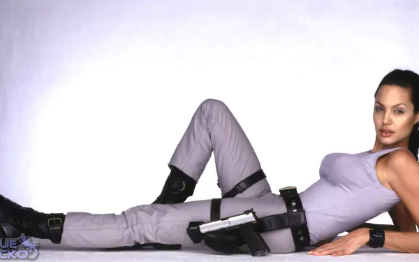 HD PC desktop wallpaper featuring Lara Croft from the movie Lara Croft: Tomb Raider in a relaxed, reclining pose with her signature outfit and weapons.