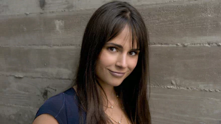 HD desktop wallpaper of Brazilian actress and celebrity Jordana Brewster smiling against a textured gray wall background.