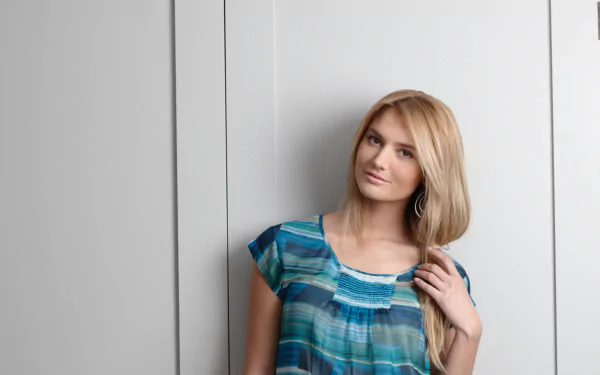 HD PC desktop wallpaper featuring French model Nadege Dabrowski posing against a light grey wall, wearing a blue patterned top.