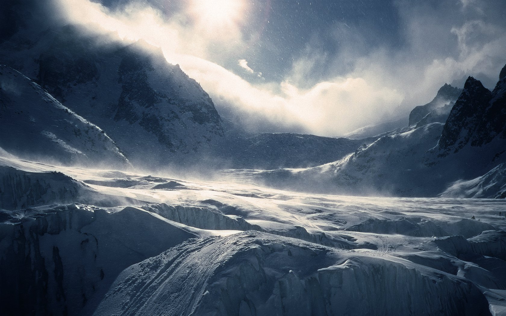 HD PC desktop wallpaper showcasing a dramatic winter mountain landscape with snow-covered peaks under a cloudy sky, capturing the serene beauty of nature.