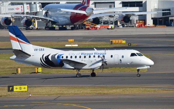 Saab 340B aircraft of City of Wagga Wagga taxiing at Sydney airport with other airplanes and terminal in the background, shown in a sharp HD desktop wallpaper.