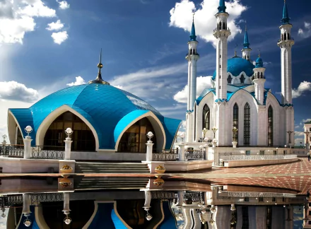 HD desktop wallpaper of the Qolşärif Mosque, a prominent religious landmark in Kazan, Russia, with blue domes and slender minarets reflected on the polished plaza under a dramatic sky.