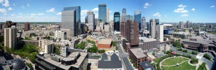 HD desktop wallpaper featuring an aerial view of downtown Minneapolis, highlighting its numerous skyscrapers and architectural diversity on a sunny day with a few clouds in the sky.