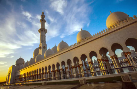 A stunning view of the Sheikh Zayed Grand Mosque in Abu Dhabi, showcasing its impressive architecture and serene atmosphere against a vibrant sky.