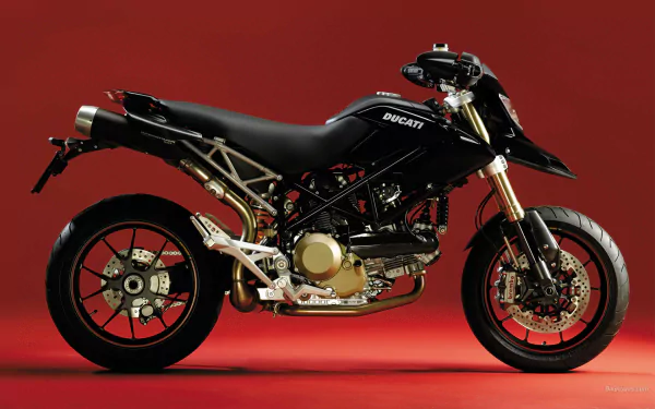 Side view of a black Ducati Hypermotard motorcycle/bike vehicle on a red backdrop — HD PC desktop wallpaper and background.