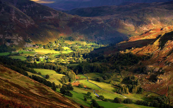 Sunlit valley and shadowed mountains in England, showcasing vibrant nature in this HD desktop wallpaper and background.