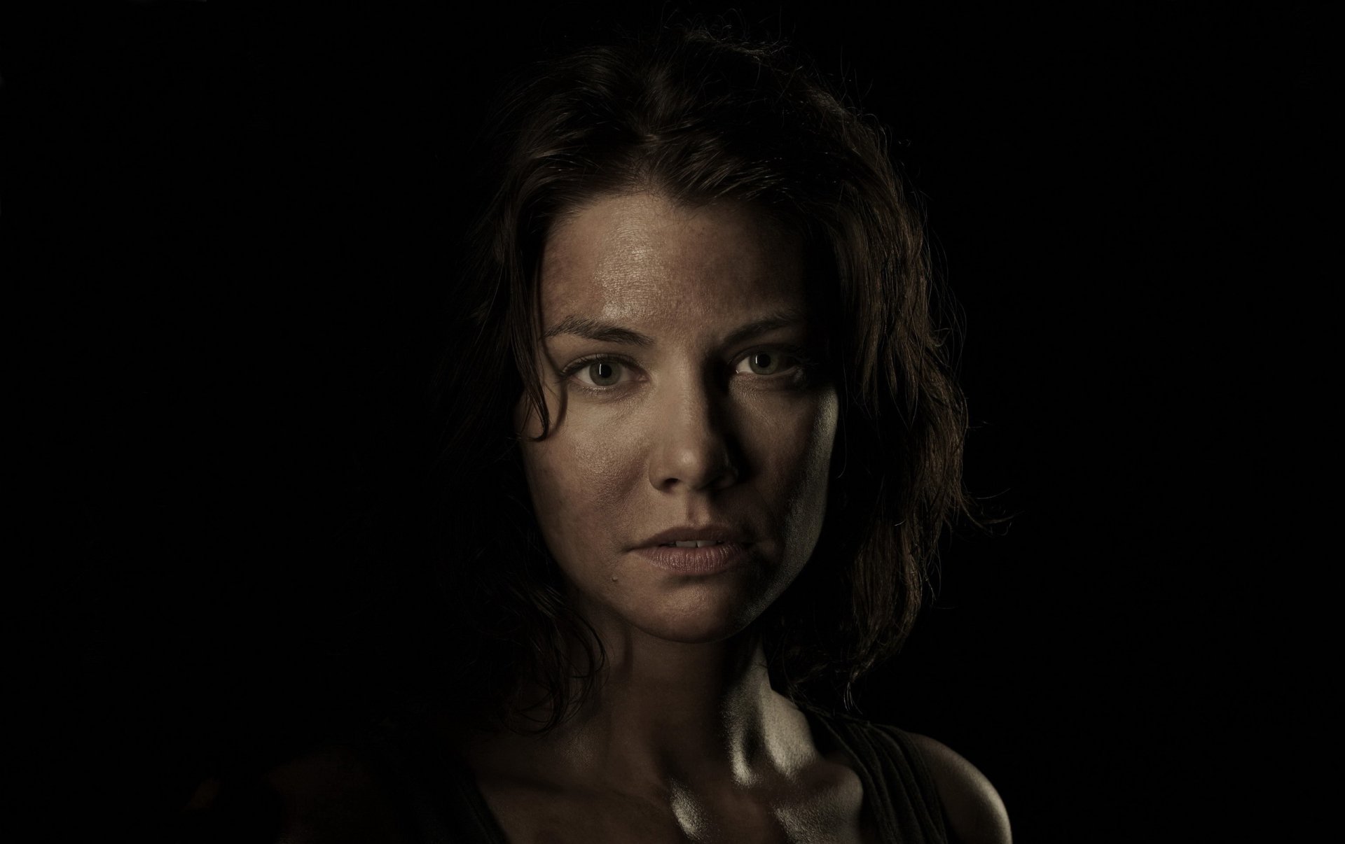 A close-up portrait of a woman with wet hair, showcasing intense emotions against a dark background, inspired by the TV show The Walking Dead, serves as an engaging HD desktop wallpaper.