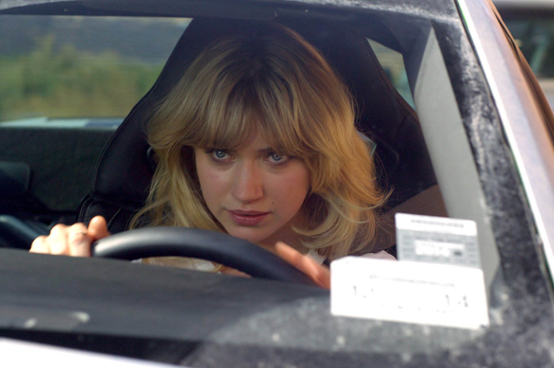 Imogen Poots drives intently in this HD desktop wallpaper from the movie Need For Speed, capturing the thrill and intensity of the racing experience.