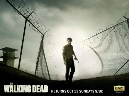 HD desktop wallpaper featuring a lone figure with a gun inside a prison yard, set in the dark, gritty world of The Walking Dead TV show.