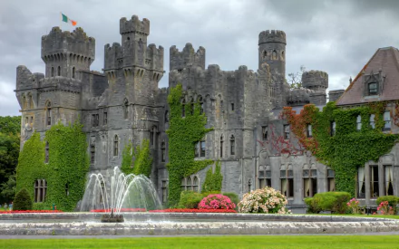 Ashford Castle man-made stone fortress with ivy-clad walls, formal gardens and fountain — 2K Quad HD PC desktop wallpaper/background.