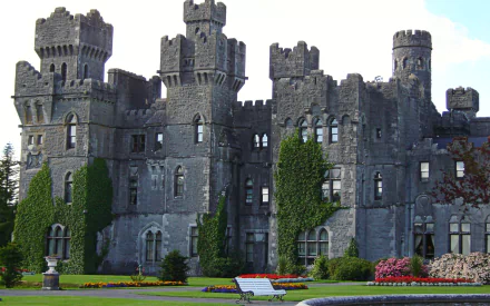 Man-made Ashford Castle stone turrets and ivy-clad walls above manicured lawns — HD PC desktop wallpaper and background.