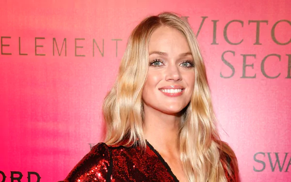 HD desktop wallpaper featuring American model Lindsay Ellingson smiling against a red Victoria’s Secret backdrop.