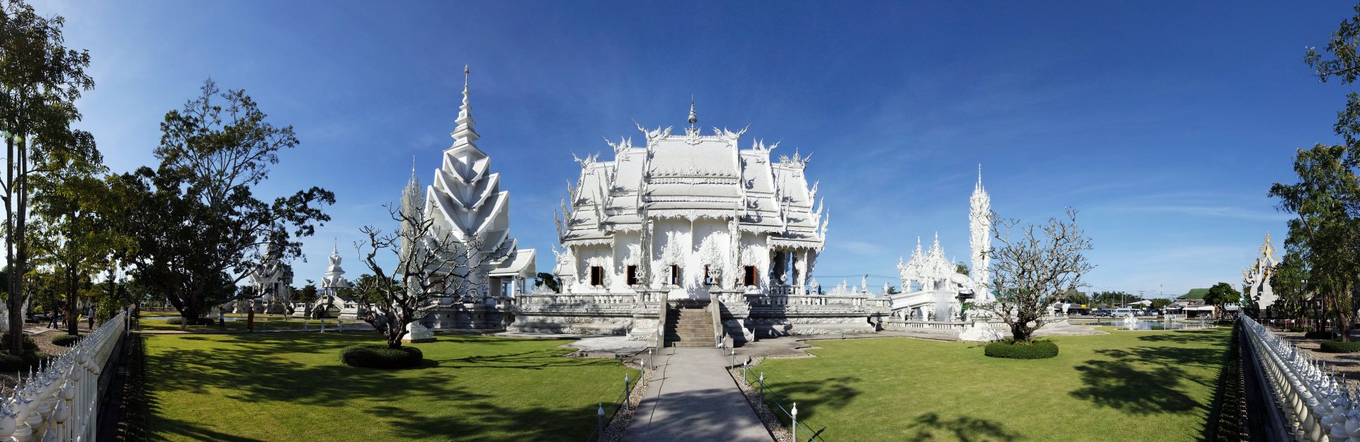 Wat Rong Khun, the striking white temple in Chiang Rai, Thailand, is showcased under a clear blue sky in this 4K Ultra HD desktop wallpaper.