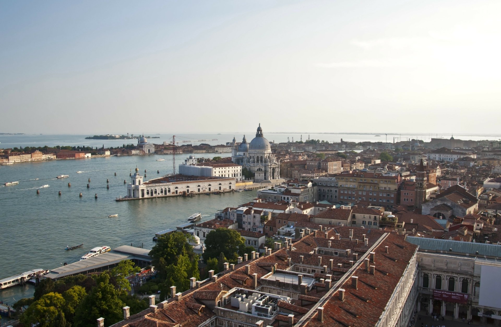 A panoramic HD view of Venice, Italy, showcasing the city's iconic canals, historic architecture, and man-made beauty under a clear sky.