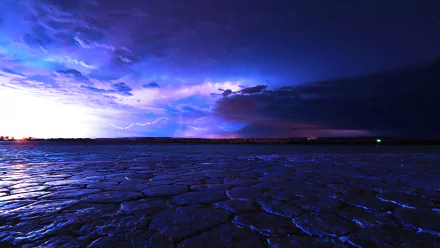 A dramatic seascape featuring a vibrant sky illuminated by lightning, casting a striking glow over textured waters. This HD wallpaper captures the essence of nature's power and beauty.